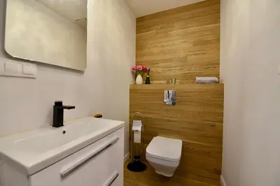 a bathroom with a white sink and a toilet at AWapartaments in Kraków