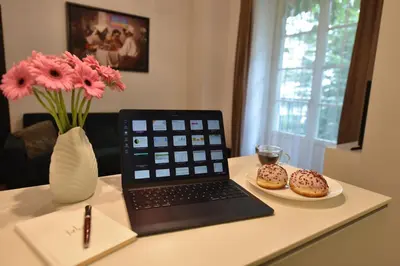 a desk with a laptop and two donuts on a plate at AWapartaments in Kraków