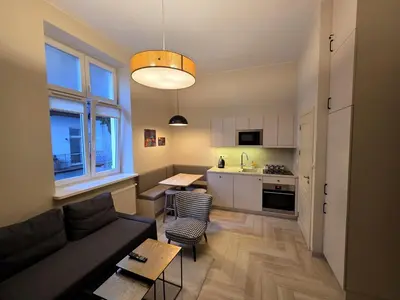 a living room with a couch and a kitchen at Kazimierz Art in Kraków