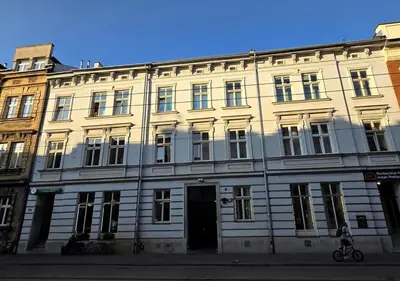 a large white building with a door on a street at Kazimierz Art in Kraków