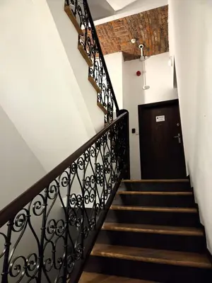 a hallway with stairs and a black door at Kazimierz Art in Kraków