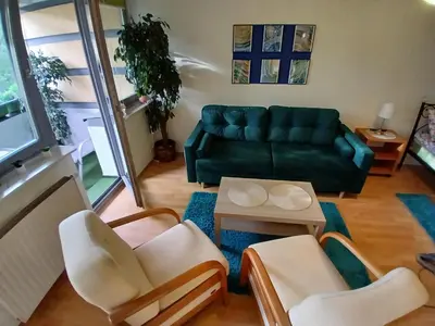 a living room with a green couch and chairs at Meadow View 10 in Kraków