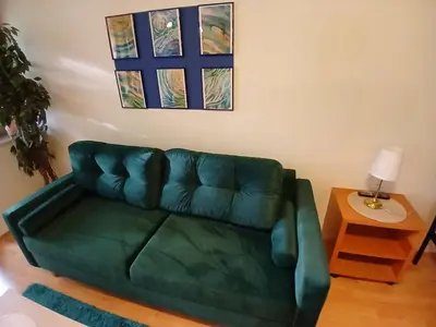 a green couch in a living room with a table at Meadow View 10 in Kraków