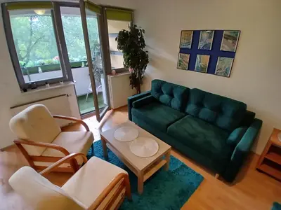 a living room with a green couch and two chairs at Meadow View 10 in Kraków