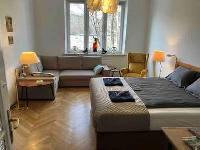 a living room with a bed and a couch at JUBILAT - 110m2 Morawskiego in Kraków