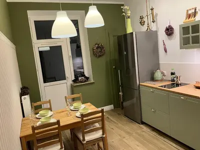 a kitchen with a table and chairs and a refrigerator at JUBILAT - 110m2 Morawskiego in Kraków