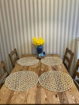 a wooden table with two chairs and a vase with yellow flowers at JUBILAT - 110m2 Morawskiego in Kraków