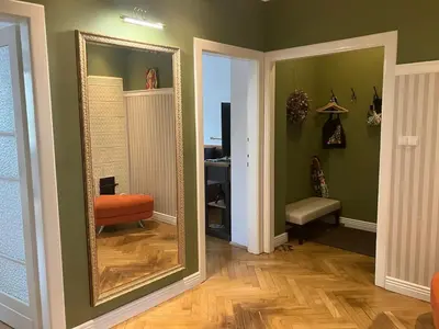 a hallway with a mirror and a chair and a desk at JUBILAT - 110m2 Morawskiego in Kraków