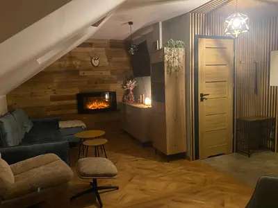 a living room with a couch and a fireplace at Sielsko Anielsko Apartament in Zawoja