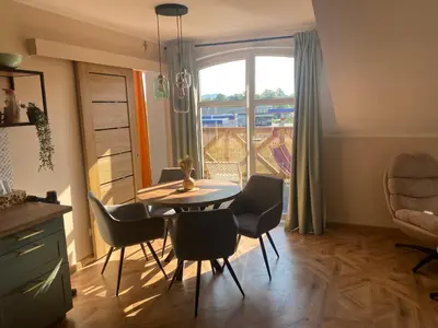 a dining room with a table and chairs and a window at Sielsko Anielsko Apartament in Zawoja