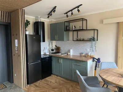 a kitchen with green cabinets and a black refrigerator at Sielsko Anielsko Apartament in Zawoja