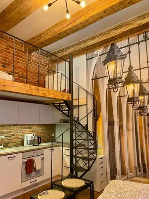 a kitchen with a spiral staircase in a room at Family Apartment with mezzanine in Kraków