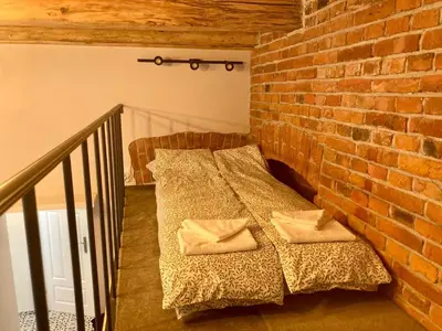 a bed in a room with a brick wall at Family Apartment with mezzanine in Kraków