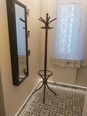 a mirror and a chair in a room with a floor at Family Apartment with mezzanine in Kraków