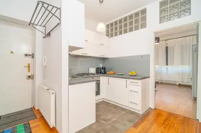 a kitchen with white cabinets and a counter top at Grzegorzki Apt - 55m2, Balcony - by Rentujemy in Kraków