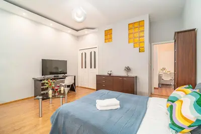 a bedroom with a blue bed and a television at Grzegorzki Apt - 55m2, Balcony - by Rentujemy in Kraków