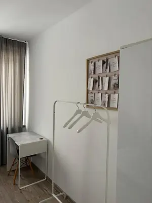 a white room with a table and a white refrigerator at Apartamenty Cisza Krakow in Kraków