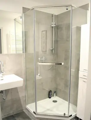 a shower with a glass door in a bathroom at Apartamenty Cisza Krakow in Kraków