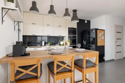 a kitchen with a wooden table and two chairs at 6th Floor Apartment in Cracow by Noclegi Renters in Kraków