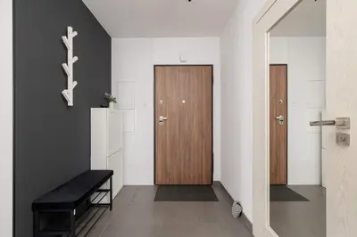 a hallway with a wooden door and a bench at 6th Floor Apartment in Cracow by Noclegi Renters in Kraków