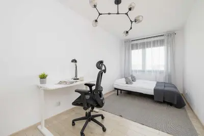 a bedroom with a bed and a desk and a chair at 6th Floor Apartment in Cracow by Noclegi Renters in Kraków