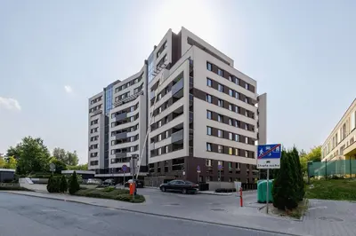 a large building with a car parked in front of it at 6th Floor Apartment in Cracow by Noclegi Renters in Kraków