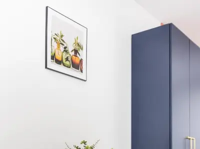 a picture hanging on a wall next to a blue cabinet at Nowoczesny apartament nad Wisłą in Kraków