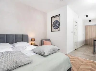 a bedroom with a bed and a clock on the wall at Nowoczesny apartament nad Wisłą in Kraków