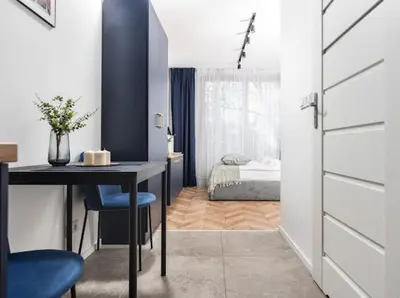 a room with a table and a bedroom with a bed at Nowoczesny apartament nad Wisłą in Kraków