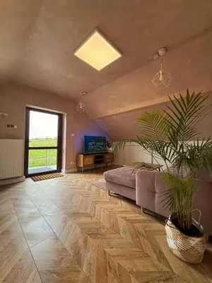 a bedroom with a bed and a potted plant at Apartament pod miastem in Lanckorona
