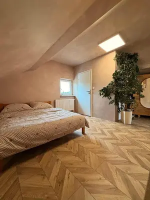 a bedroom with a bed and a wooden floor at Apartament pod miastem in Lanckorona