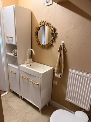 a bathroom with a white sink and a mirror at Apartament pod miastem in Lanckorona