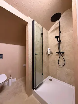 a bathroom with a shower with a glass door at Apartament pod miastem in Lanckorona