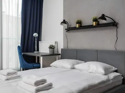 a bedroom with a bed with towels on it at Nowoczesny apartament nad Wisłą II in Kraków