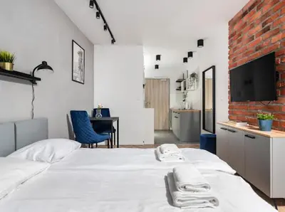 a bedroom with a white bed with towels on it at Nowoczesny apartament nad Wisłą II in Kraków