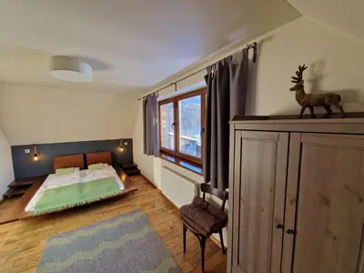 a bedroom with a bed and a window at Garden Apartament Kurnik in Stróża
