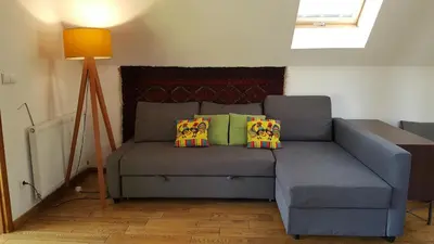 a blue couch with pillows on it in a room at Garden Apartament Kurnik in Stróża