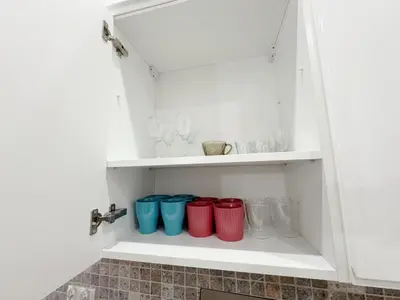 a cupboard with four red and blue glasses at Mariacki apartment in Kraków