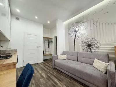 a living room with a couch and a kitchen at Mariacki apartment in Kraków