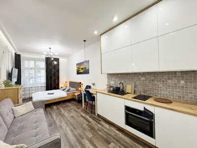 a kitchen and living room with a couch and a table at Mariacki apartment in Kraków