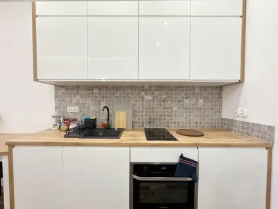 a kitchen with white cabinets and a counter top at Mariacki apartment in Kraków