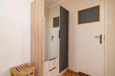 a hallway with a white door and a wooden stool at Nowowiejska Cosy Studio for 6 people in Cracow by Noclegi Renters in Kraków