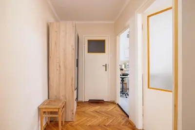 a hallway with a door and a wooden stool at Nowowiejska Cosy Studio for 6 people in Cracow by Noclegi Renters in Kraków