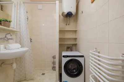 a bathroom with a washing machine and a sink at Nowowiejska Cosy Studio for 6 people in Cracow by Noclegi Renters in Kraków
