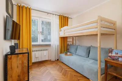 a living room with a blue couch and a bunk bed at Nowowiejska Cosy Studio for 6 people in Cracow by Noclegi Renters in Kraków