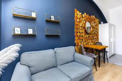 a living room with a couch and a blue wall at Rently Apartments in Old Town in Kraków