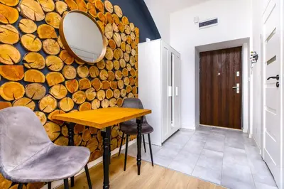 a room with a table and chairs and a wall of logs at Rently Apartments in Old Town in Kraków
