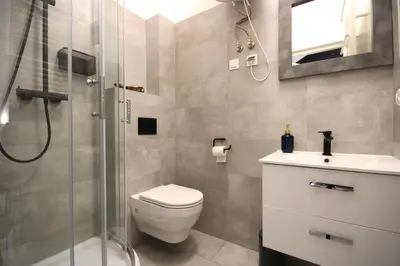 a bathroom with a shower and a toilet and a sink at Rently Apartments in Old Town in Kraków