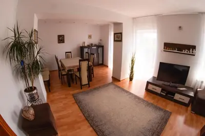 a living room with a television and a table with chairs at Dom w Chomranicach- Jacuzzi, domek grillowy in Chomranice