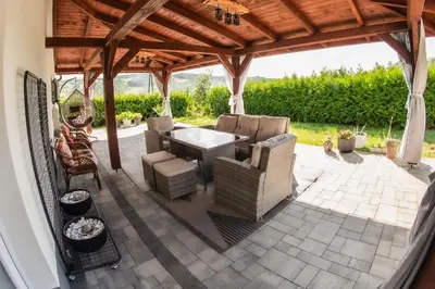 a patio with a table and chairs under a pavilion at Dom w Chomranicach- Jacuzzi, domek grillowy in Chomranice